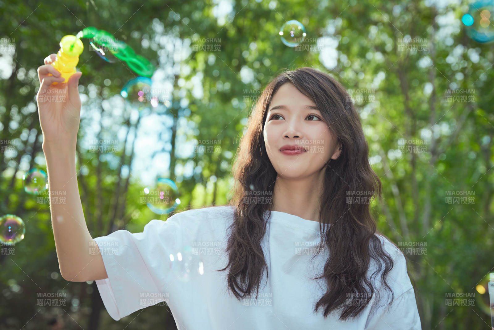 户外公园里玩吹泡泡的可爱亚洲少女图片