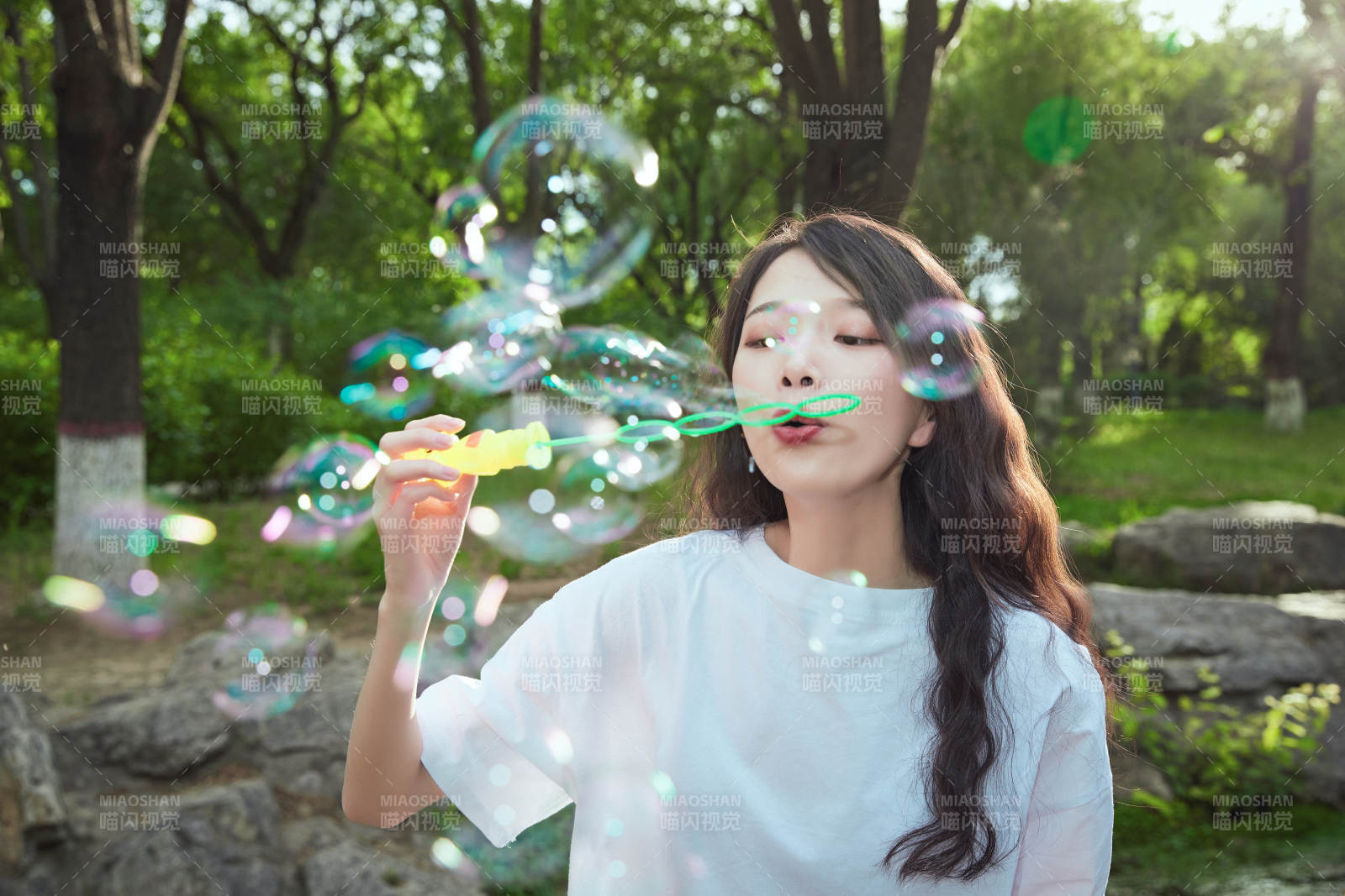 户外公园里玩吹泡泡的可爱亚洲少女图片