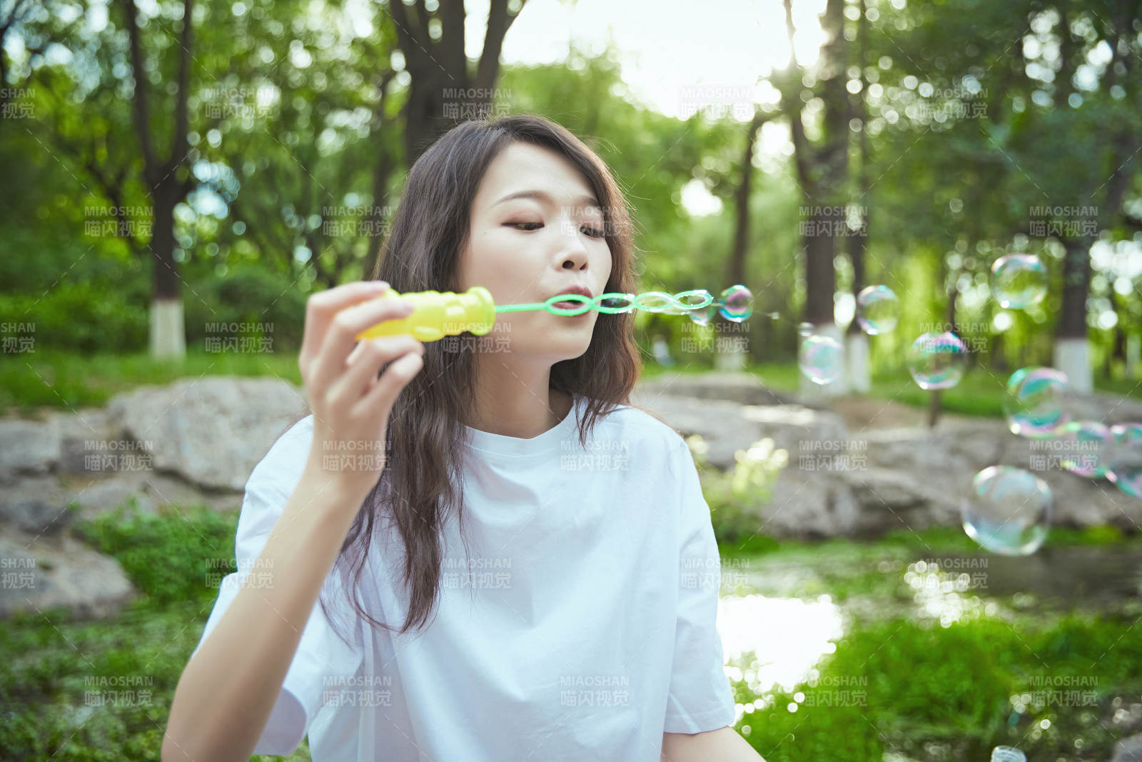 户外公园里玩吹泡泡的可爱亚洲少女图片