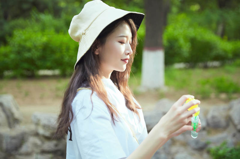 户外公园里玩吹泡泡的可爱亚洲少女图片