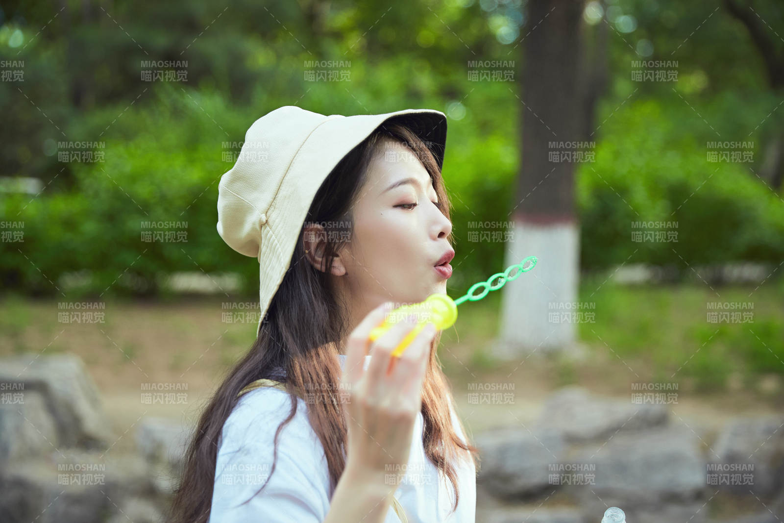 户外公园里玩吹泡泡的可爱亚洲少女图片