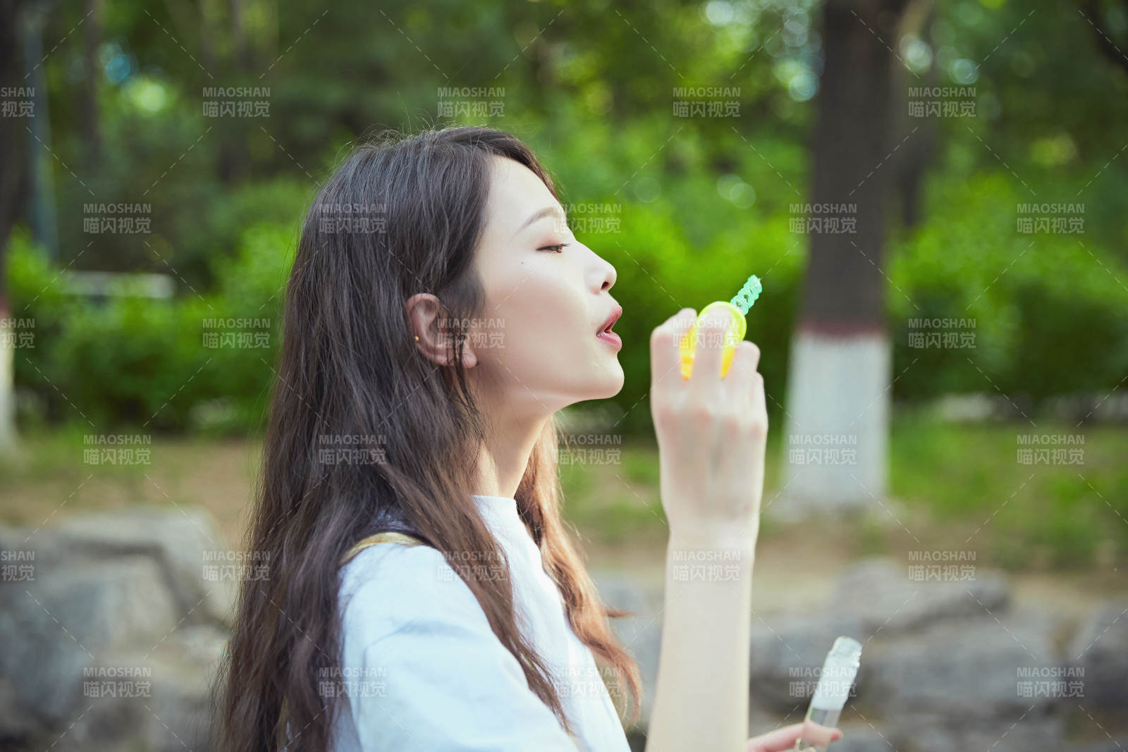 户外公园里玩吹泡泡的可爱亚洲少女图片