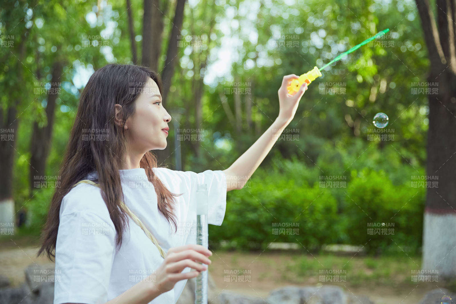 户外公园里玩吹泡泡的可爱亚洲少女图片