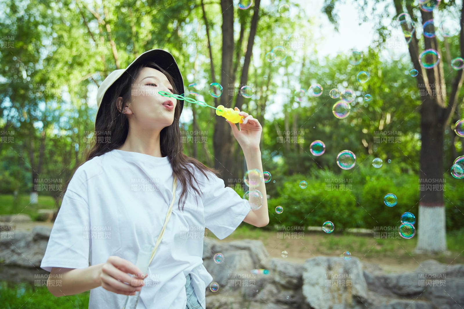 户外公园里玩吹泡泡的可爱亚洲少女图片