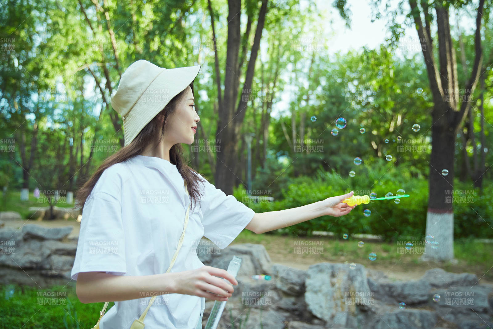 户外公园里玩吹泡泡的可爱亚洲少女图片