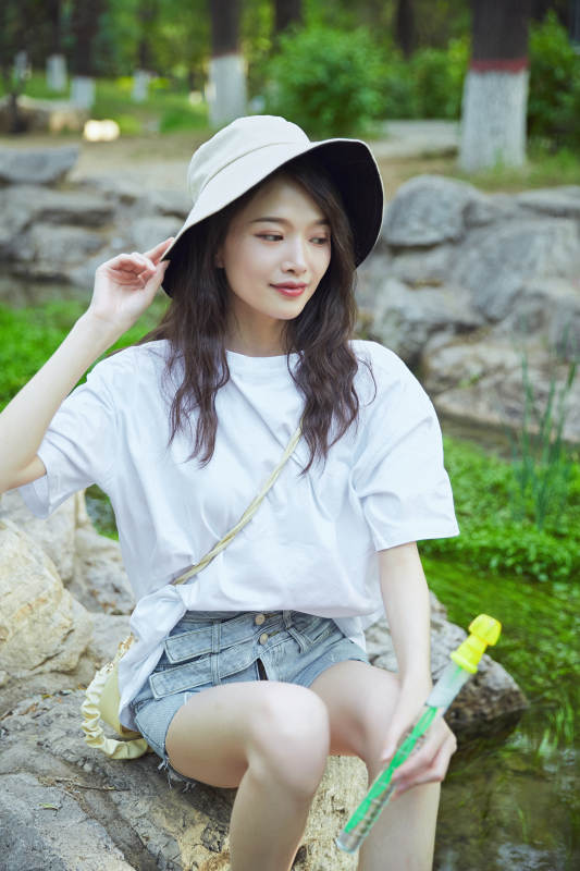 户外公园小溪旁悠闲惬意的亚洲少女图片