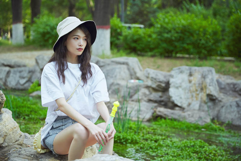 户外公园小溪旁悠闲惬意的亚洲少女图片