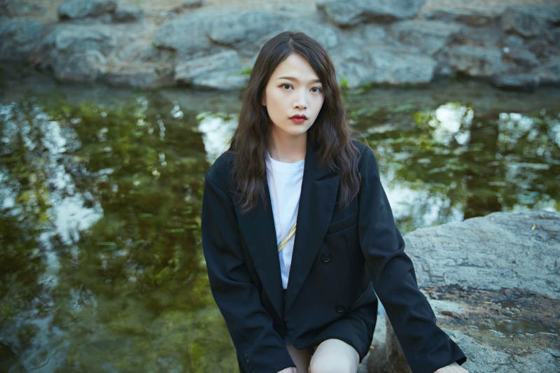 户外公园小溪旁悠闲惬意的亚洲少女图片