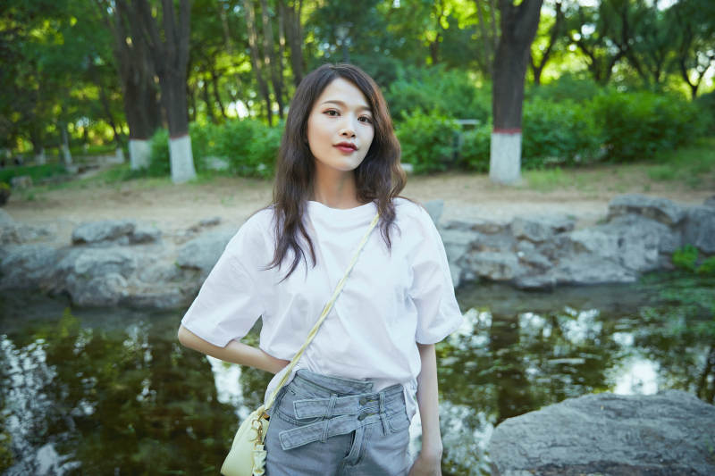 户外公园小溪旁悠闲惬意的亚洲少女图片