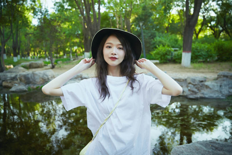 户外公园小溪旁悠闲惬意的亚洲少女图片