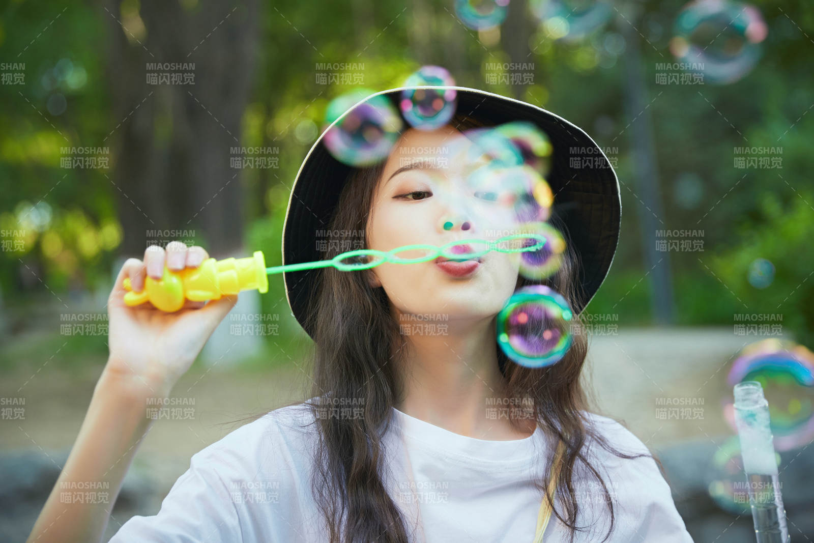 户外公园里玩吹泡泡的可爱亚洲少女图片