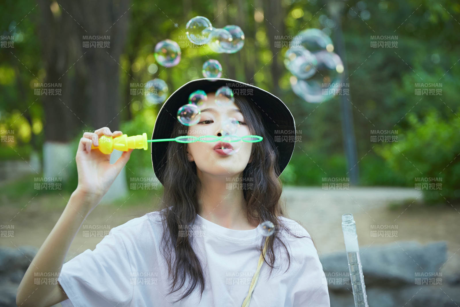 户外公园里玩吹泡泡的可爱亚洲少女图片