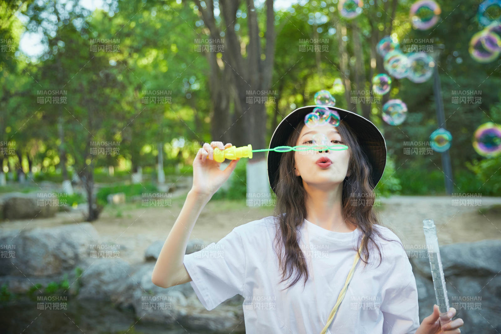户外公园里玩吹泡泡的可爱亚洲少女图片