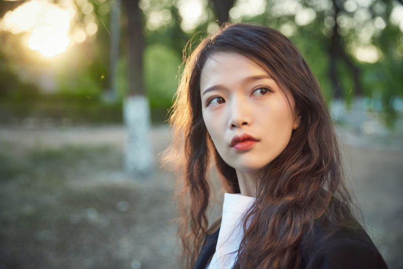 户外公园夕阳下逆光拍摄的亚洲美少女图片