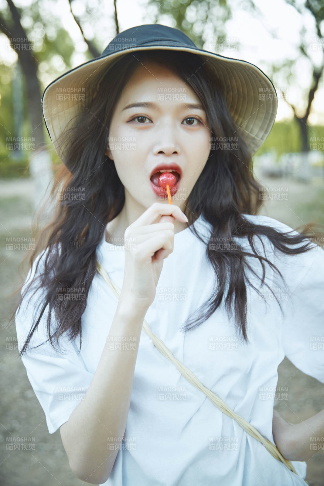 公园湖边吃棒棒糖的亚洲可爱少女图片