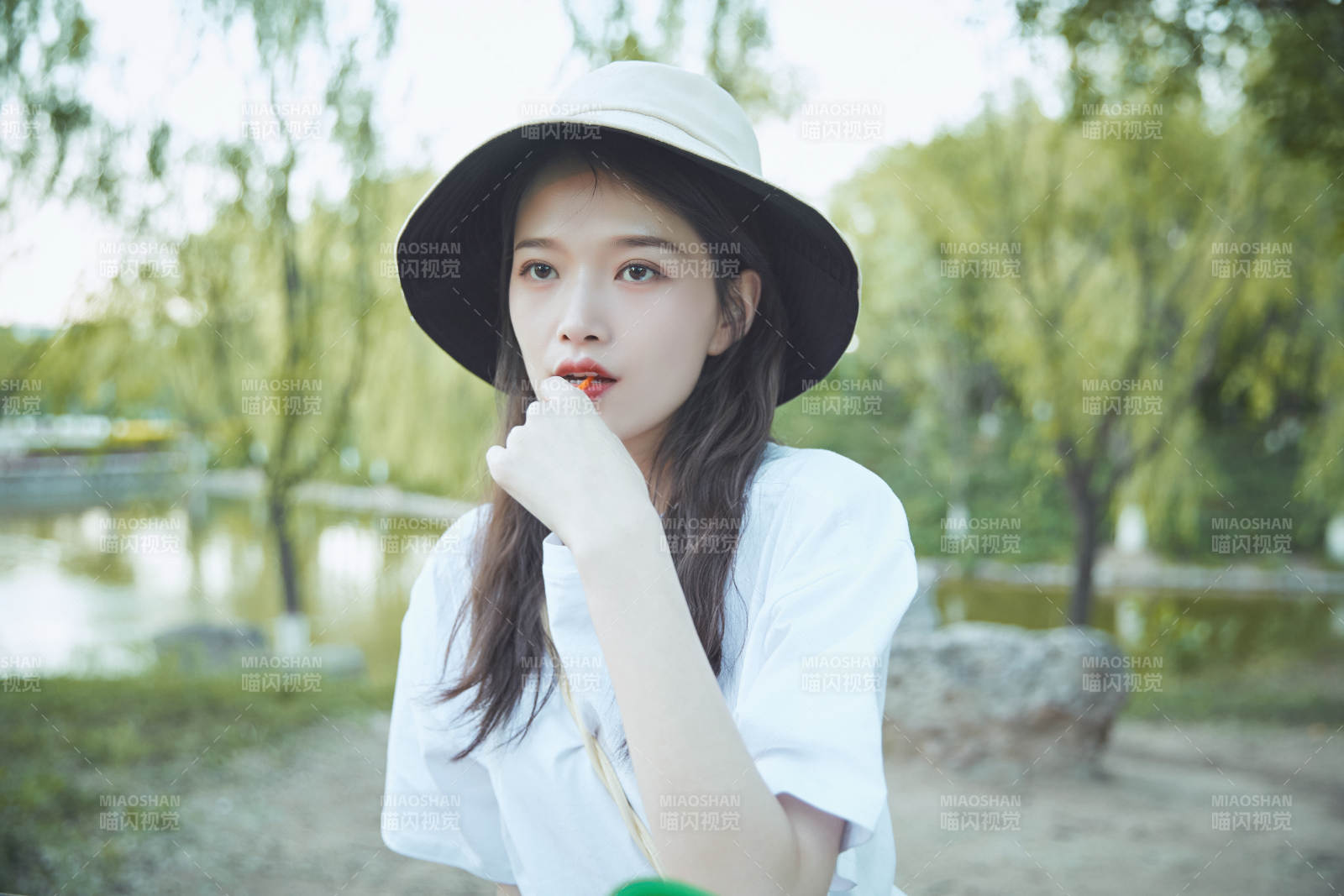 公园湖边吃棒棒糖的亚洲可爱少女图片