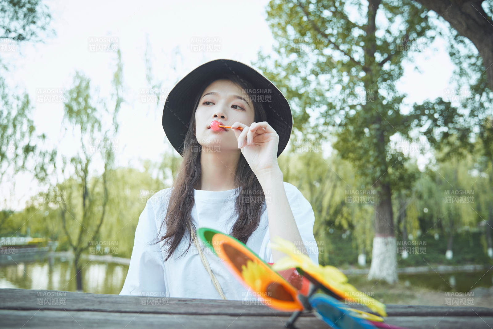 公园湖边吃棒棒糖的亚洲可爱少女图片