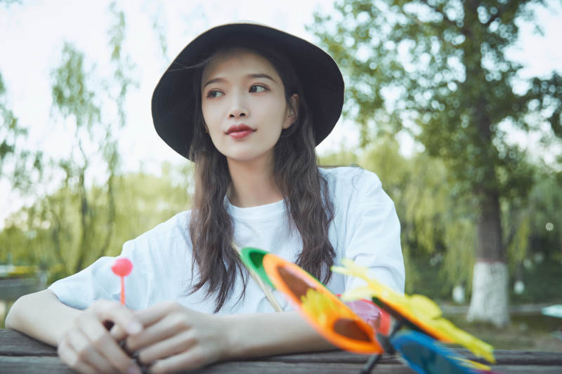 公园湖边吃棒棒糖的亚洲可爱少女图片