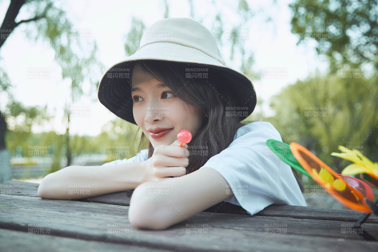 公园湖边吃棒棒糖的亚洲可爱少女图片