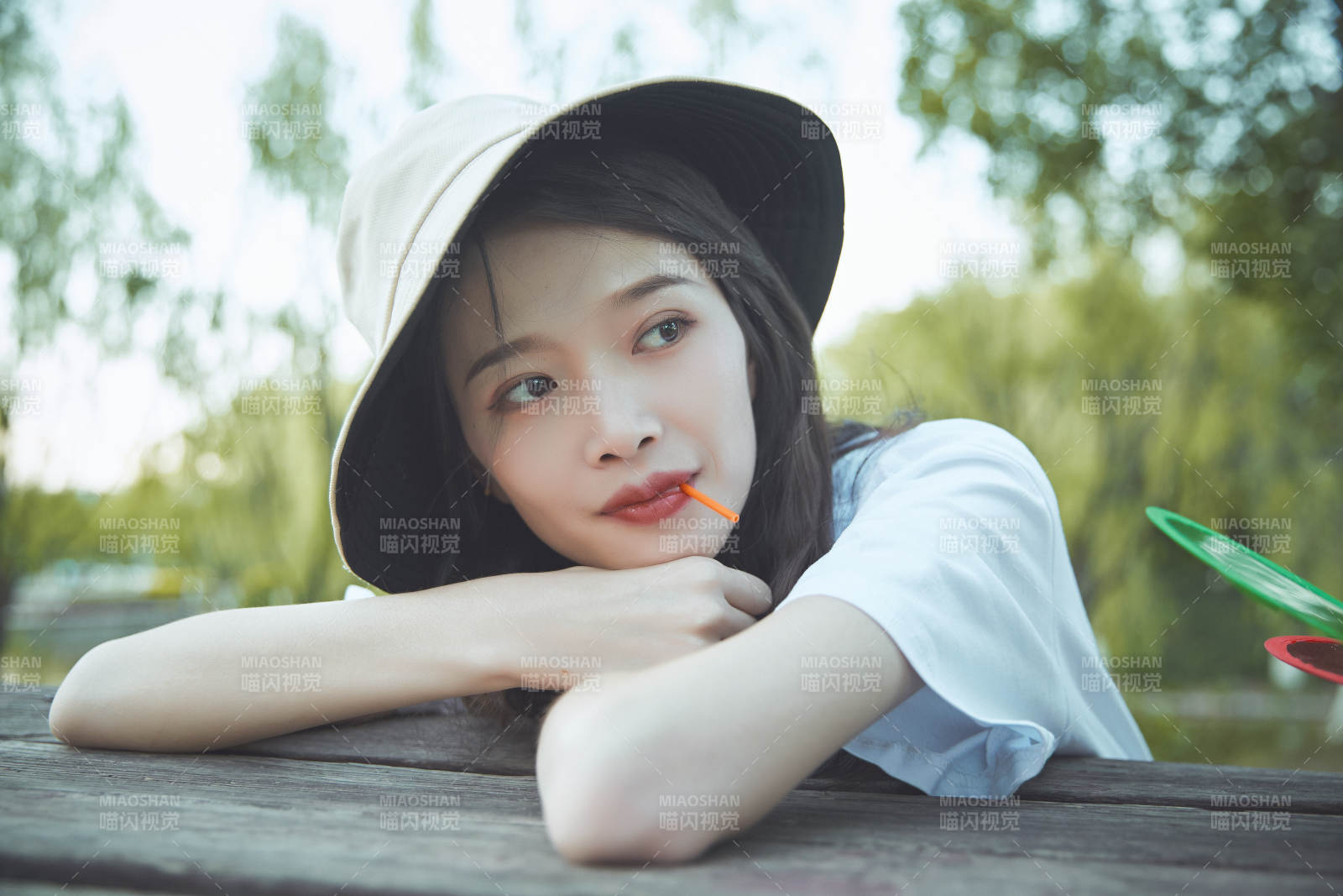 公园湖边吃棒棒糖的亚洲可爱少女图片