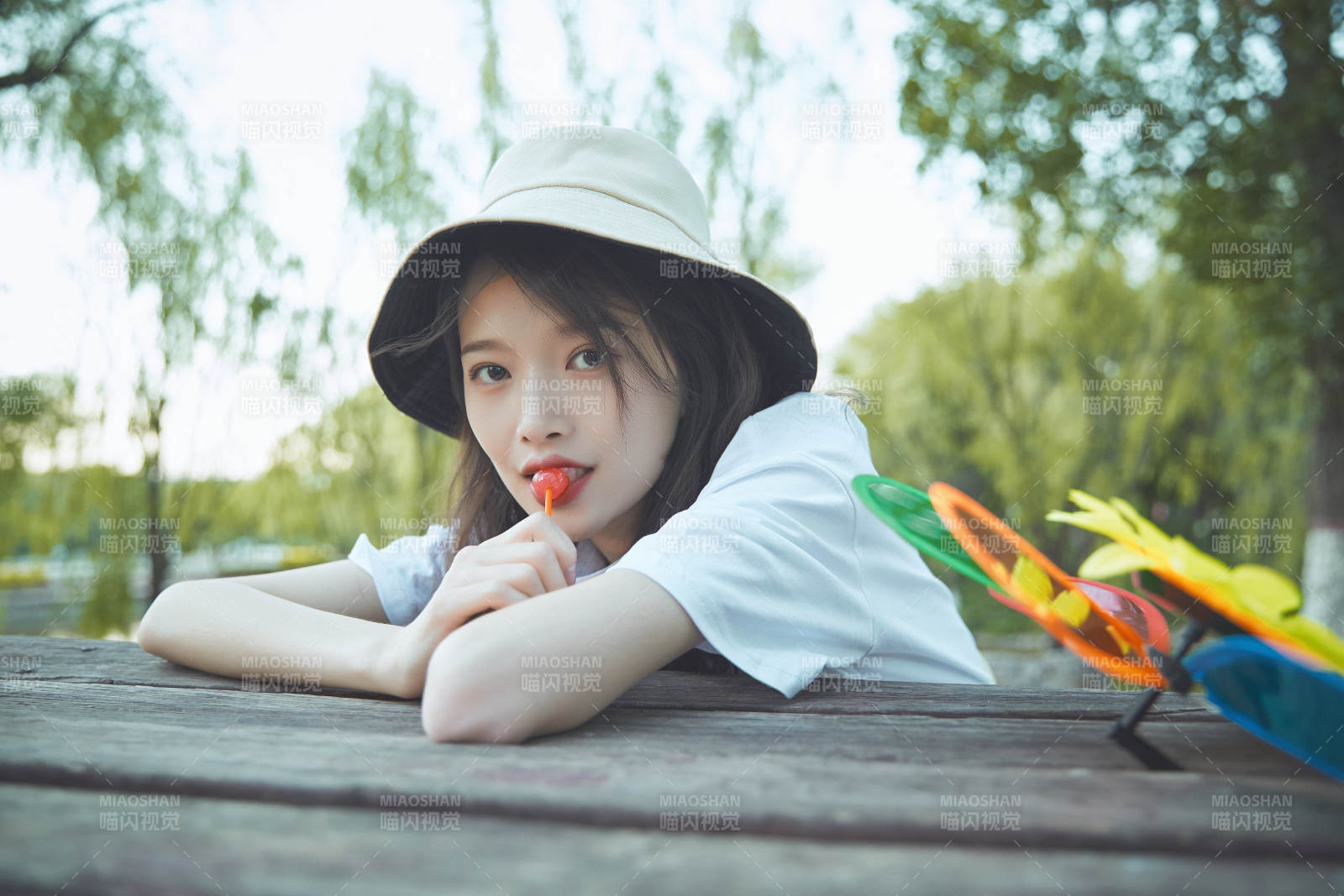 公园湖边吃棒棒糖的亚洲可爱少女图片