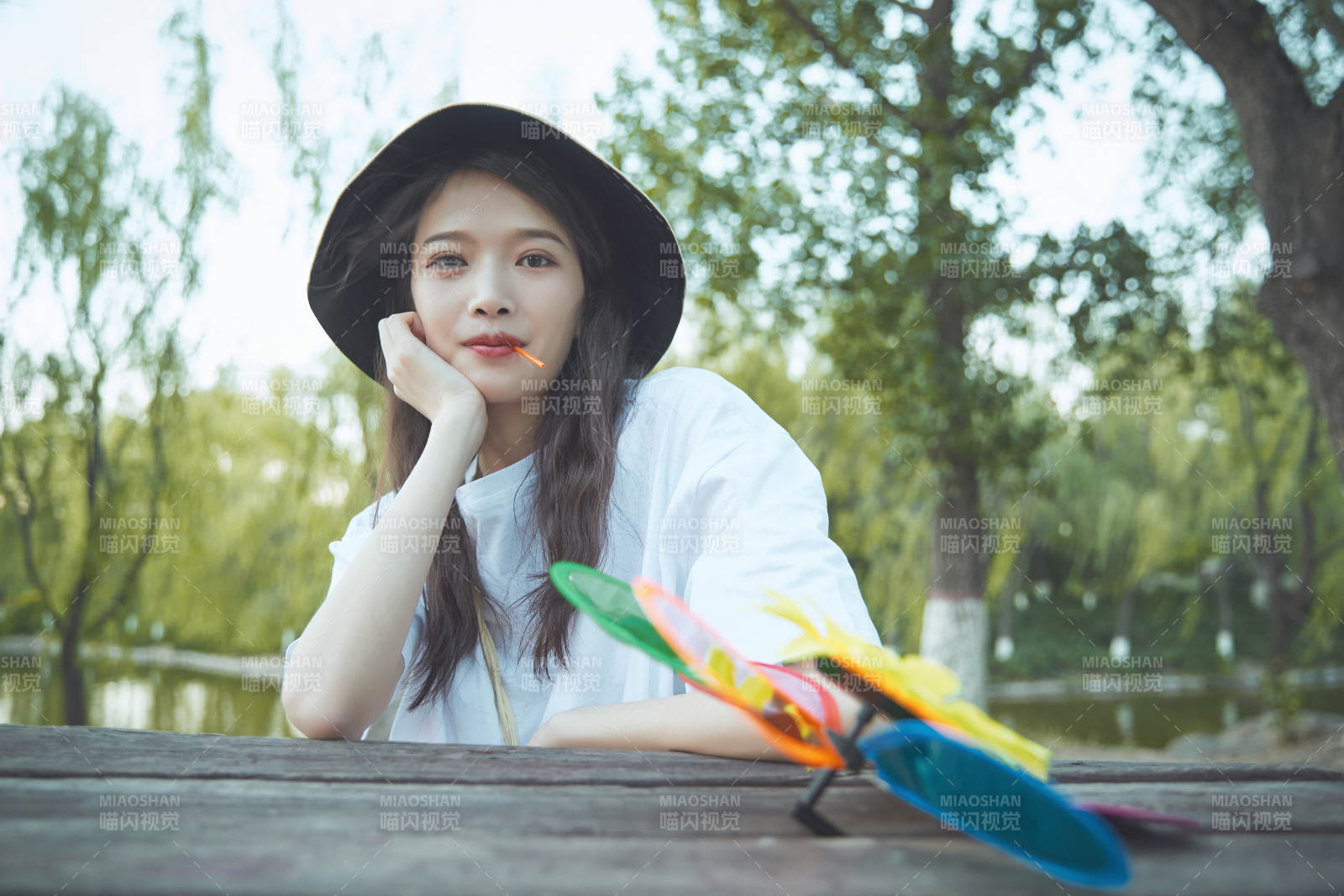 公园湖边吃棒棒糖的亚洲可爱少女图片