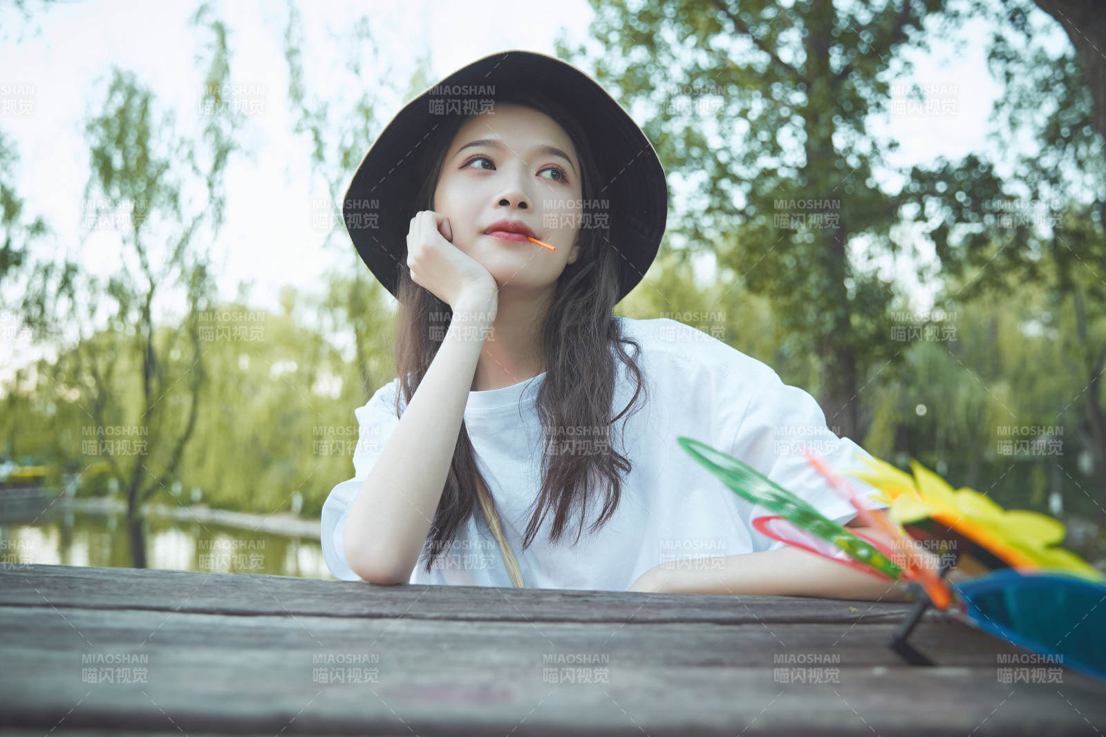 公园湖边吃棒棒糖的亚洲可爱少女图片