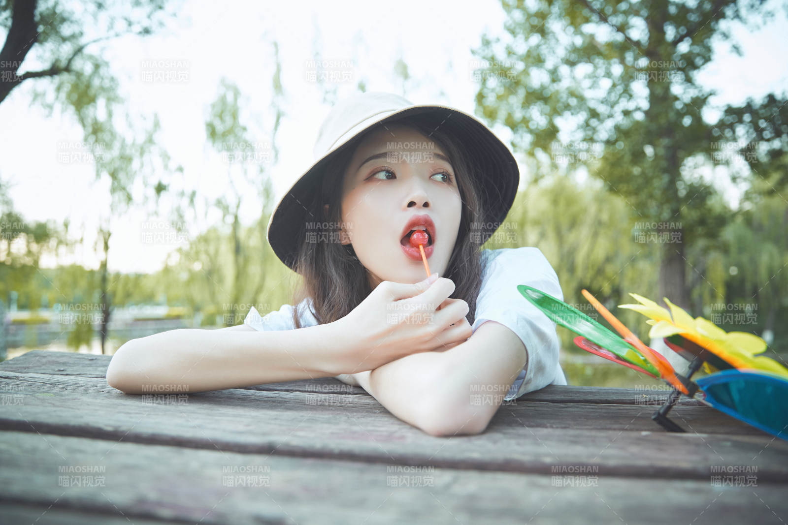 公园湖边吃棒棒糖的亚洲可爱少女图片
