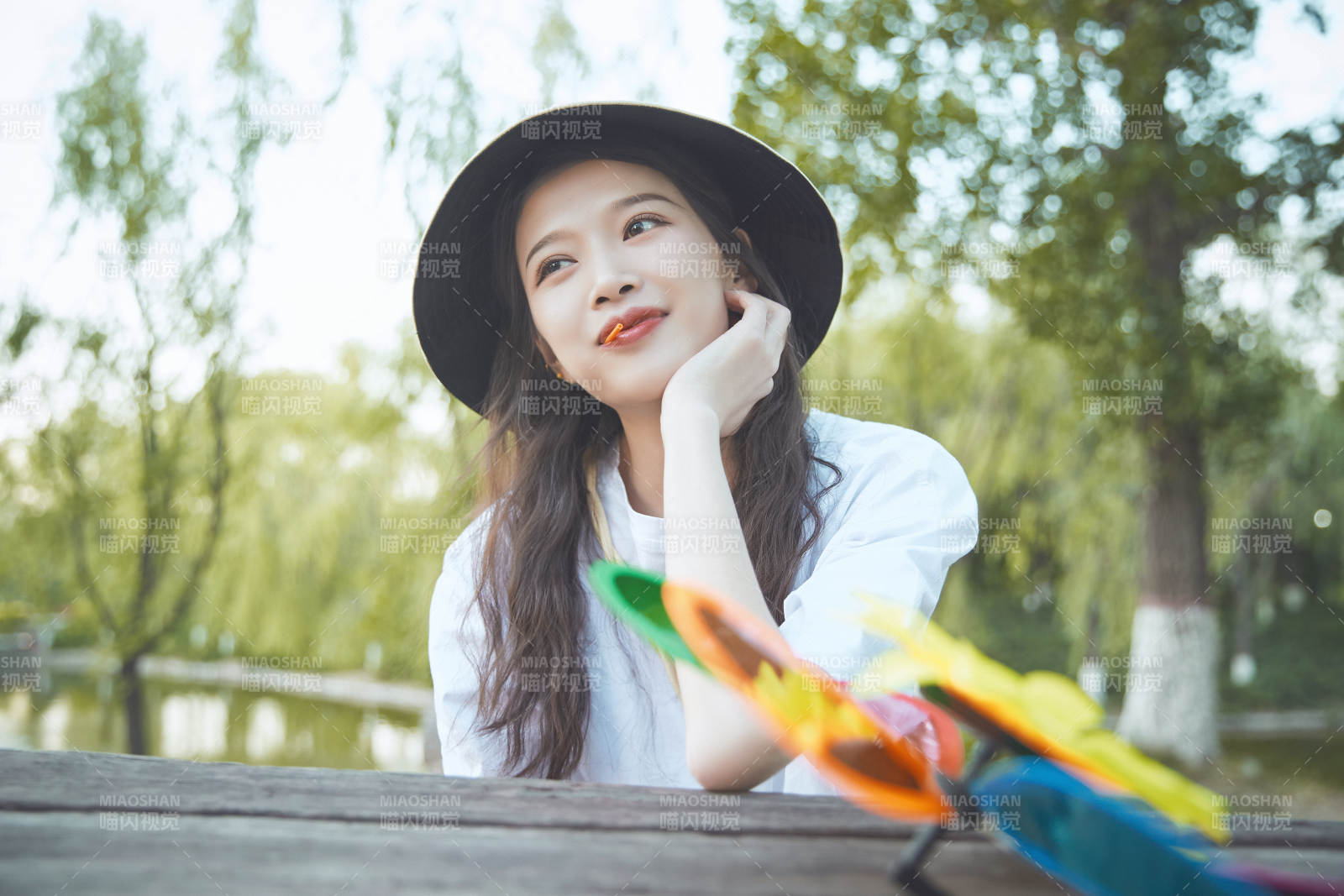 公园湖边吃棒棒糖的亚洲可爱少女图片