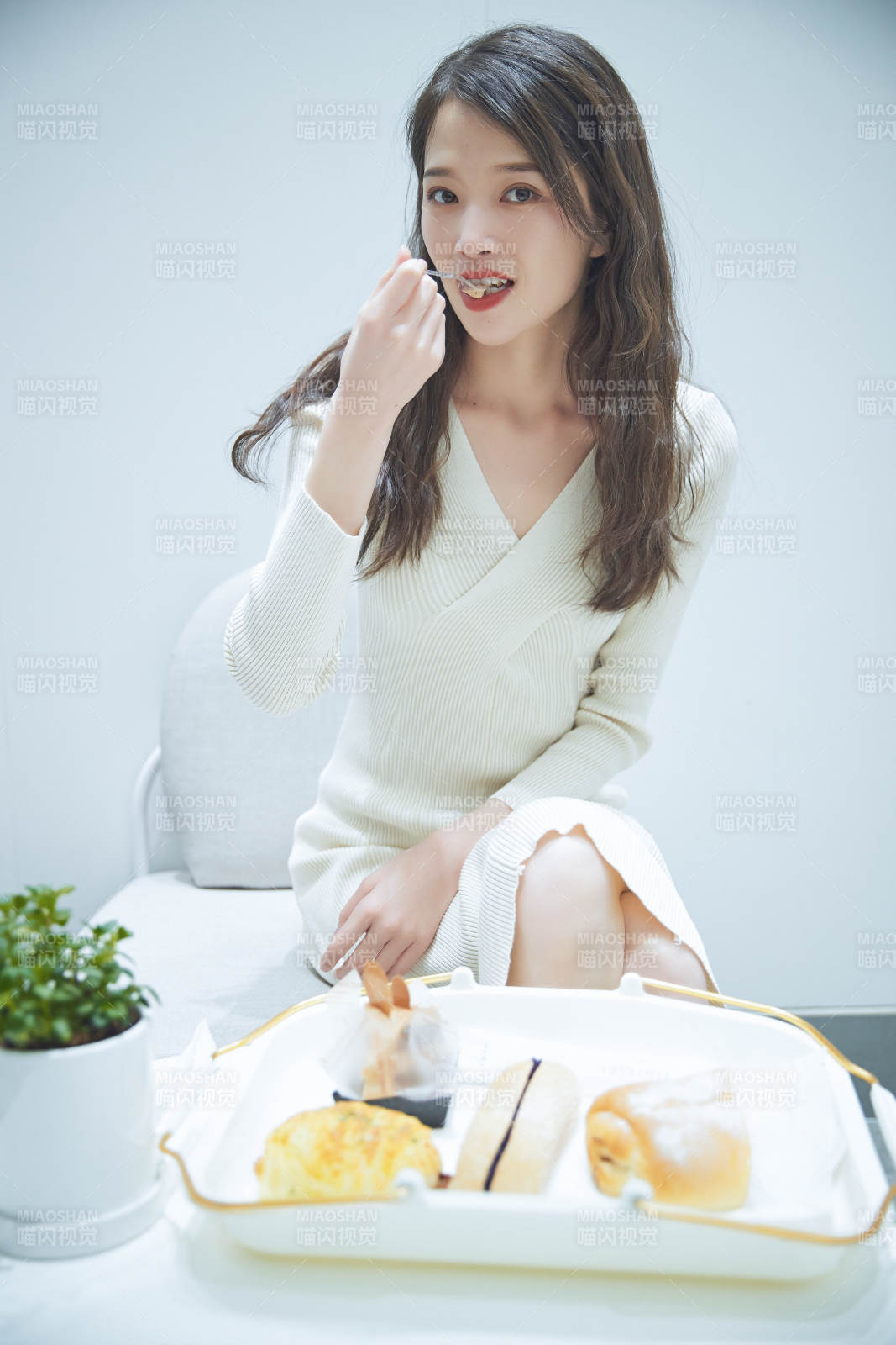 在烘焙店吃面包喝牛奶的可爱亚洲少女图片