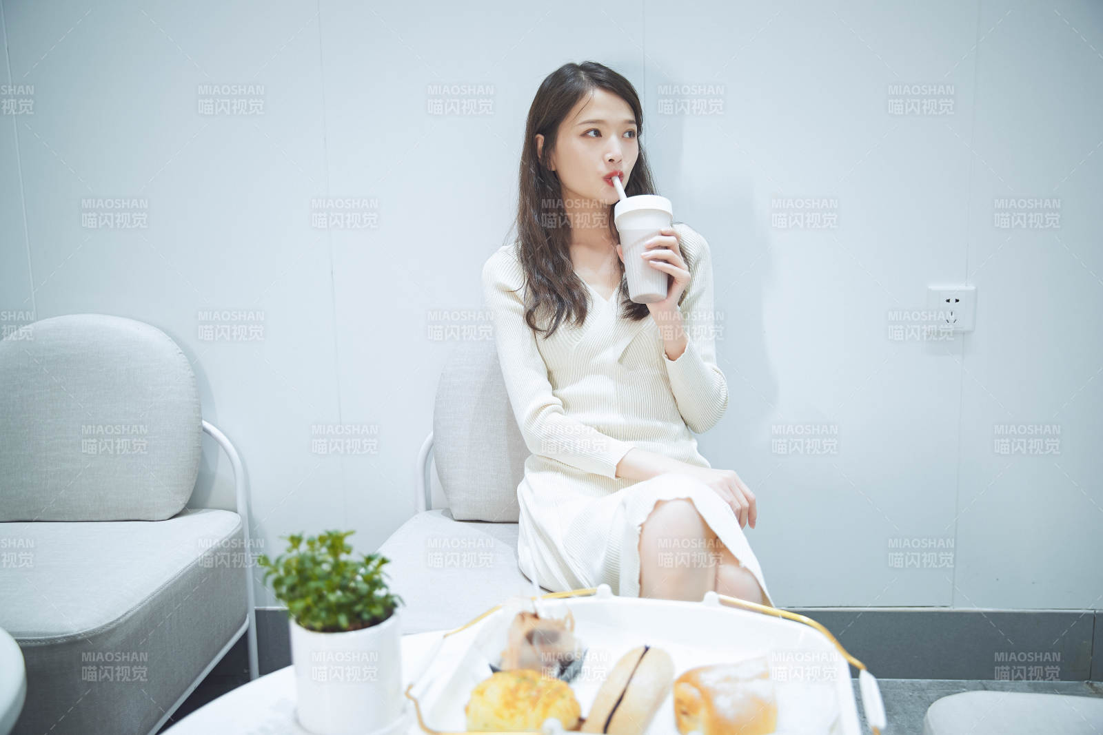 在烘焙店吃面包喝牛奶的可爱亚洲少女图片