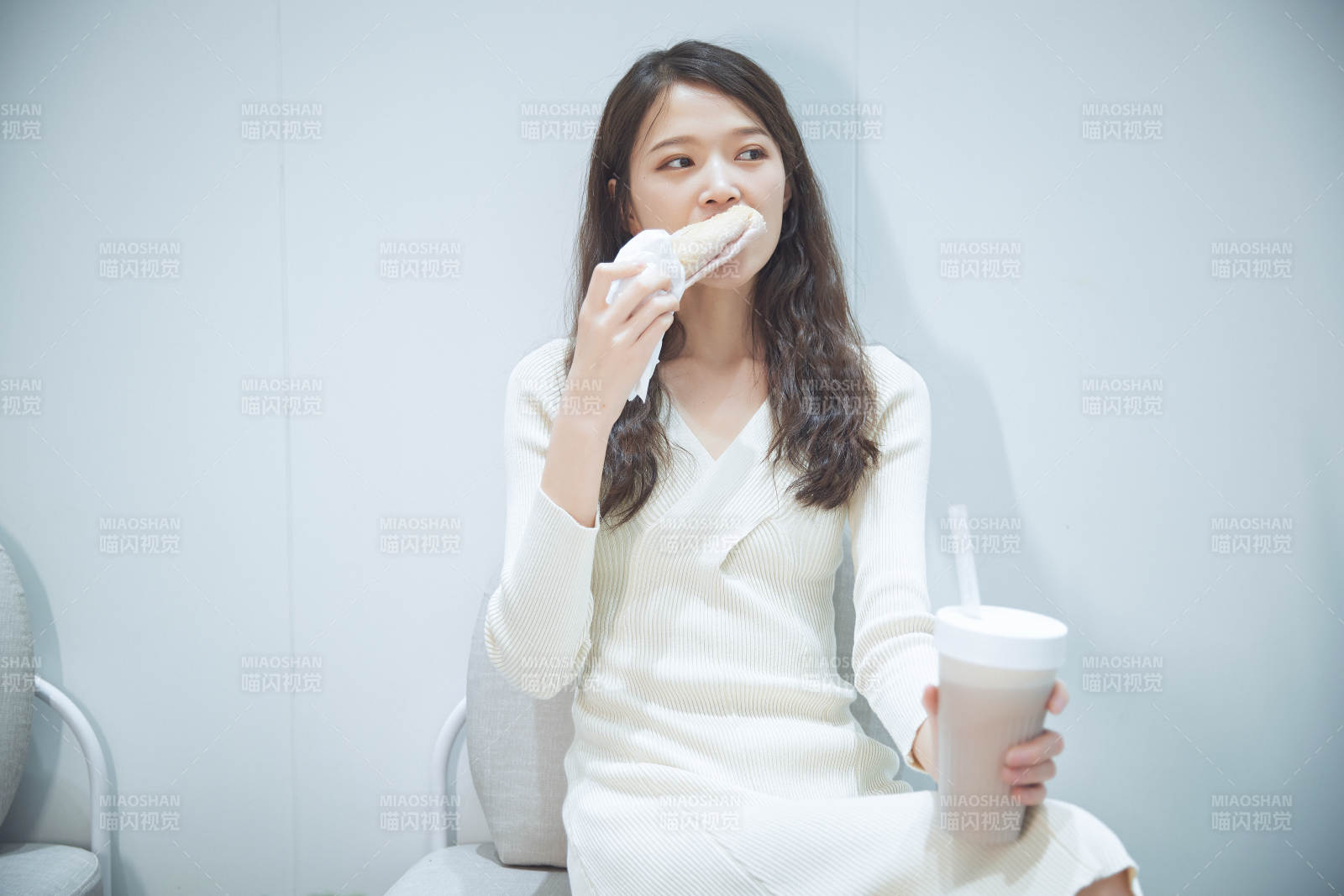 在烘焙店吃面包喝牛奶的可爱亚洲少女图片