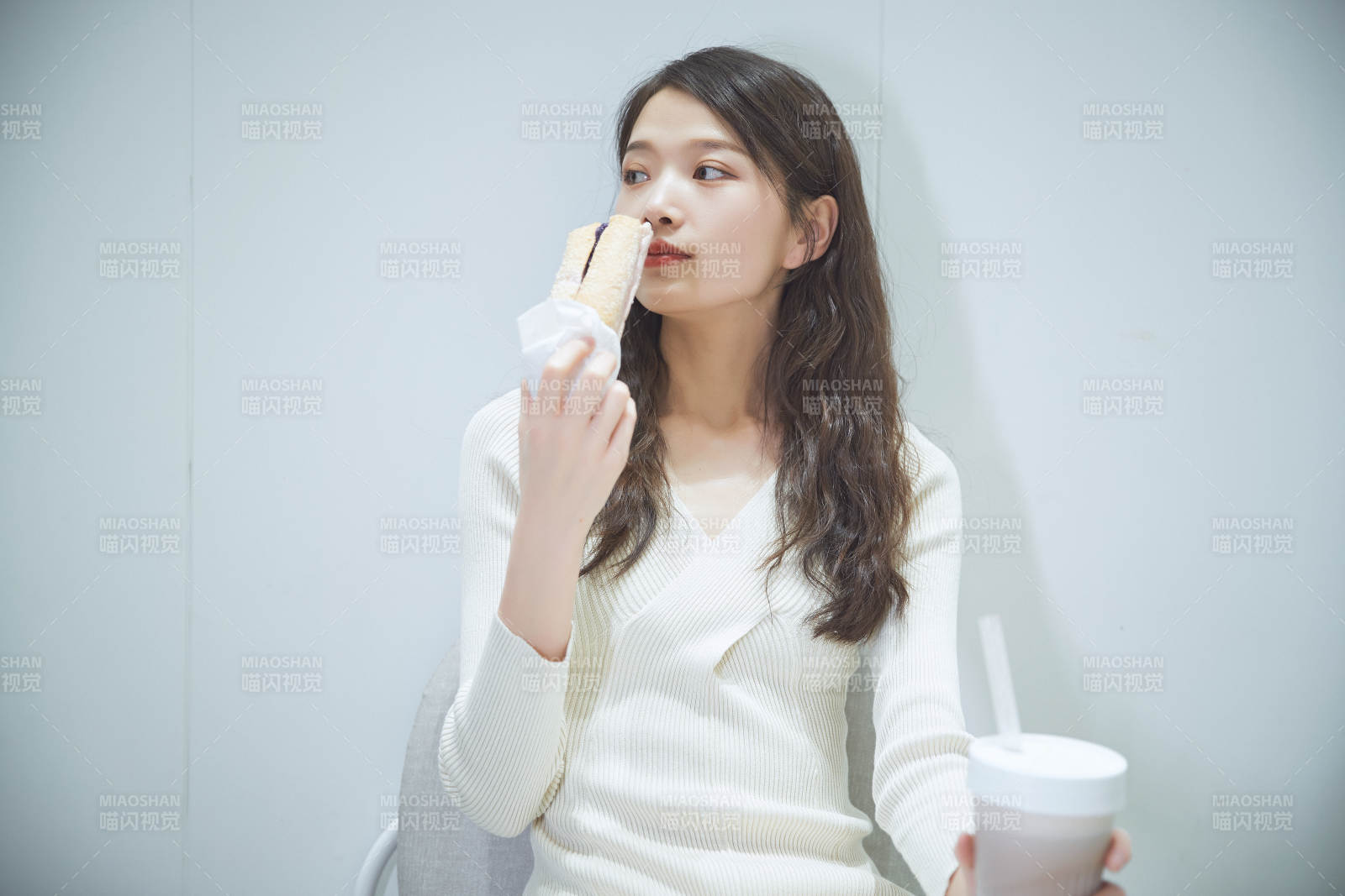 在烘焙店吃面包喝牛奶的可爱亚洲少女图片