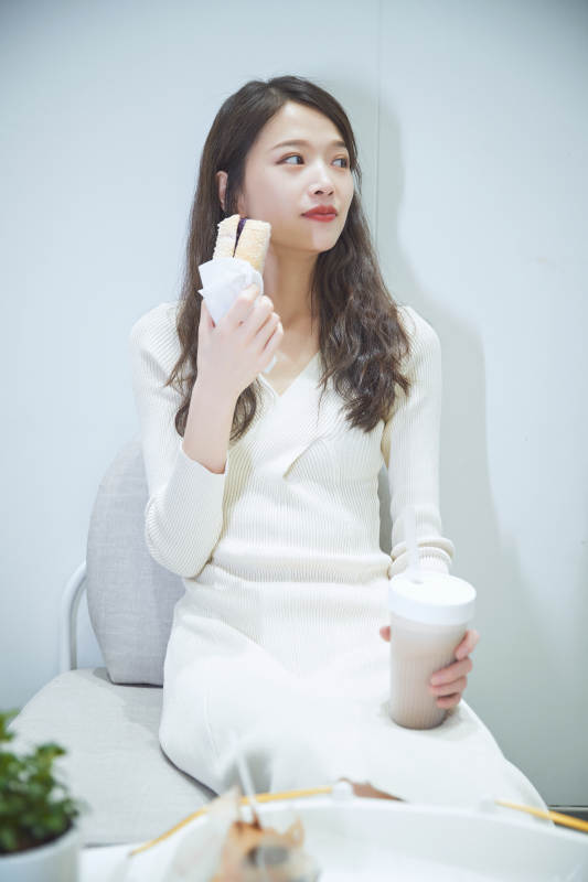 在烘焙店吃面包喝牛奶的可爱亚洲少女图片