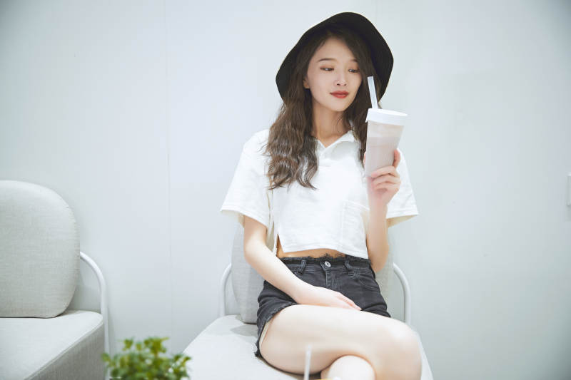 在烘焙店吃面包喝牛奶的可爱亚洲少女图片