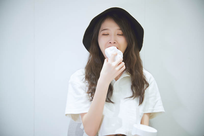 在烘焙店吃面包喝牛奶的可爱亚洲少女图片