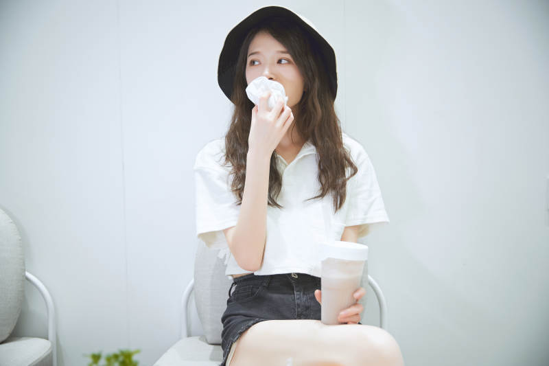 在烘焙店吃面包喝牛奶的可爱亚洲少女图片