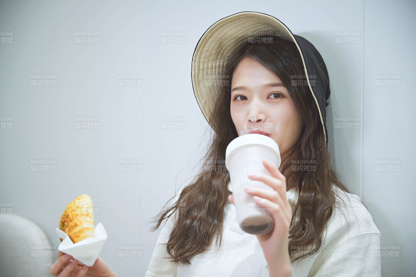 在烘焙店吃面包喝牛奶的可爱亚洲少女图片