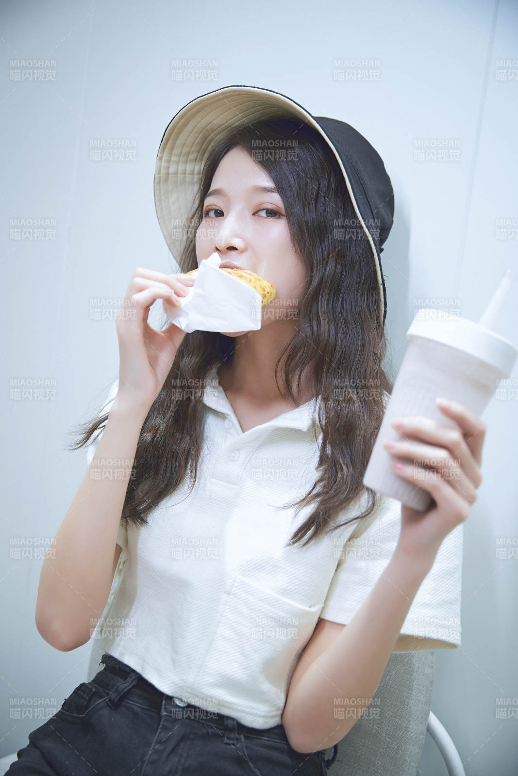 在烘焙店吃面包喝牛奶的可爱亚洲少女图片