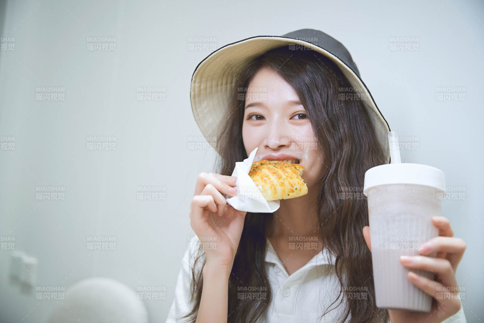 在烘焙店吃面包喝牛奶的可爱亚洲少女图片