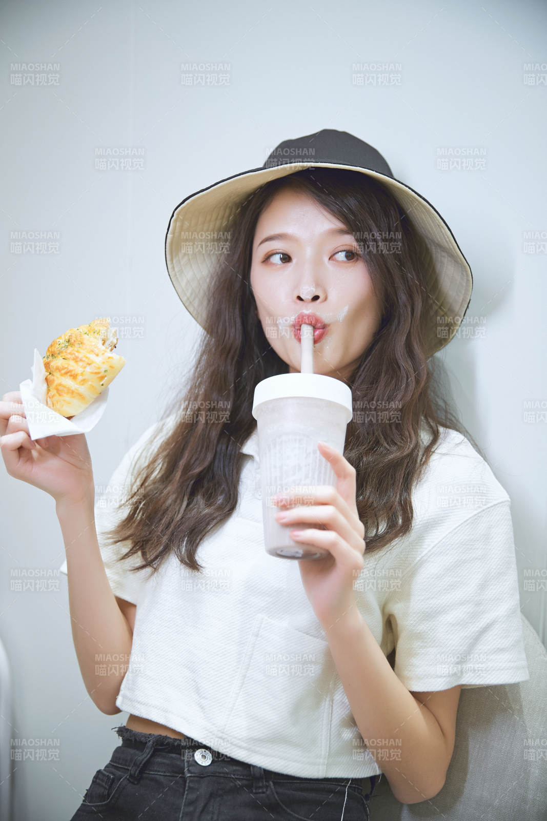 在烘焙店吃面包喝牛奶的可爱亚洲少女图片