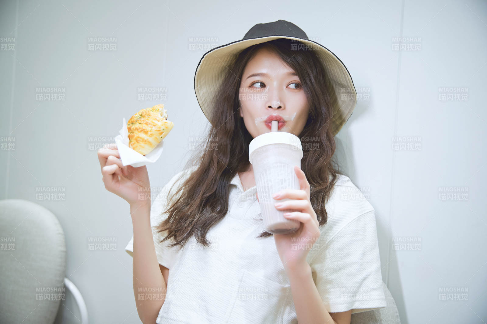 在烘焙店吃面包喝牛奶的可爱亚洲少女图片