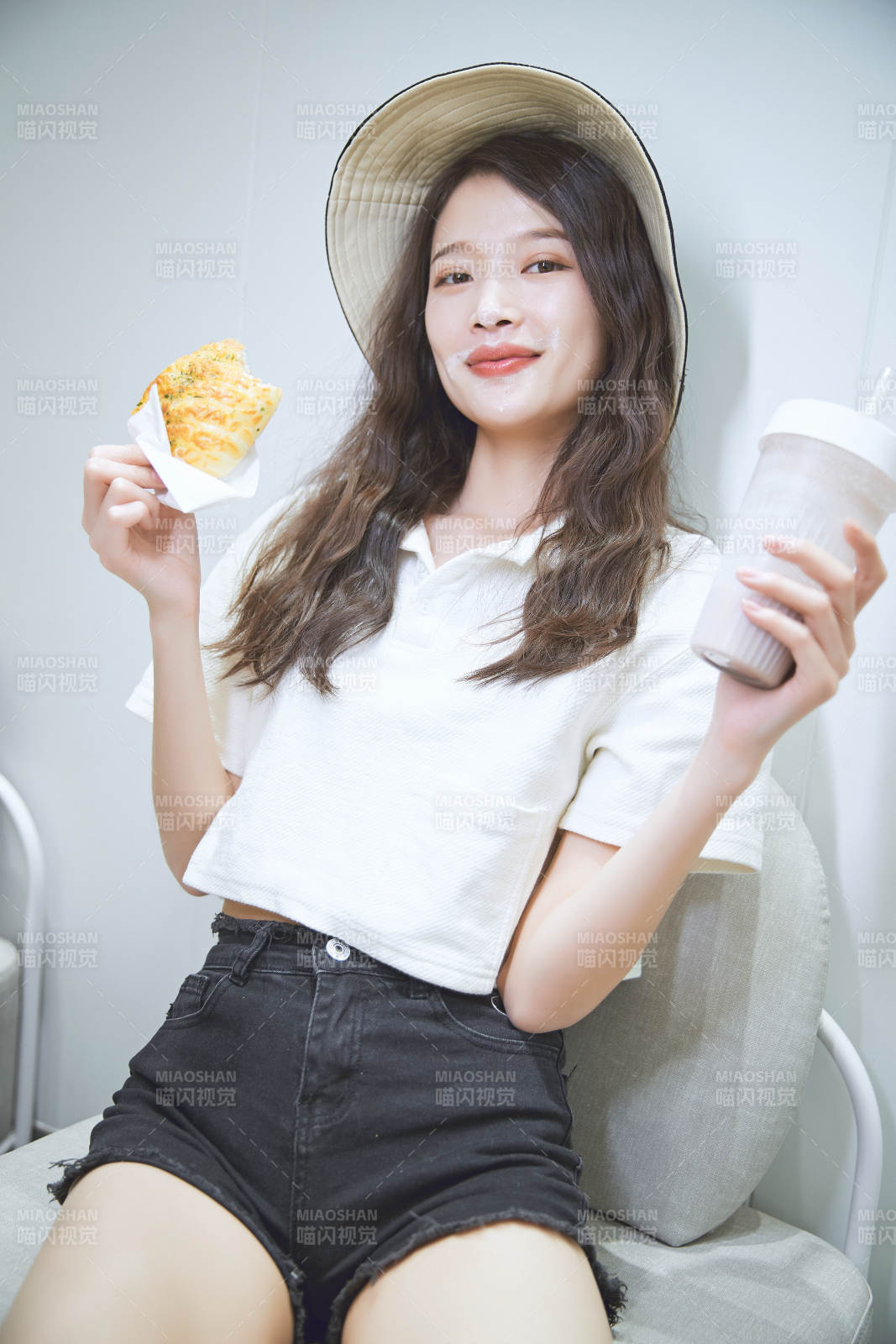 在烘焙店吃面包喝牛奶的可爱亚洲少女图片