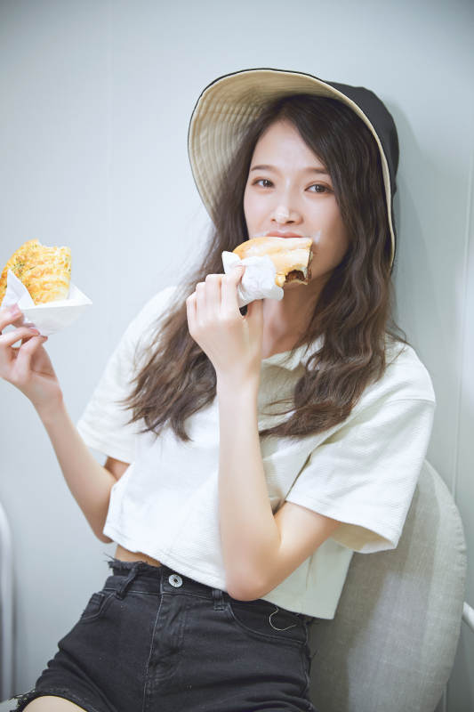 在烘焙店吃面包喝牛奶的可爱亚洲少女图片