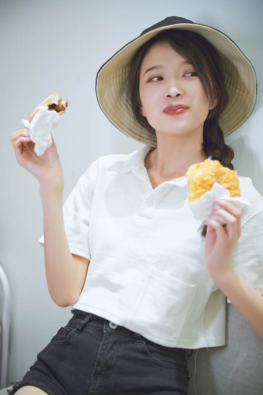 在烘焙店吃面包喝牛奶的可爱亚洲少女图片