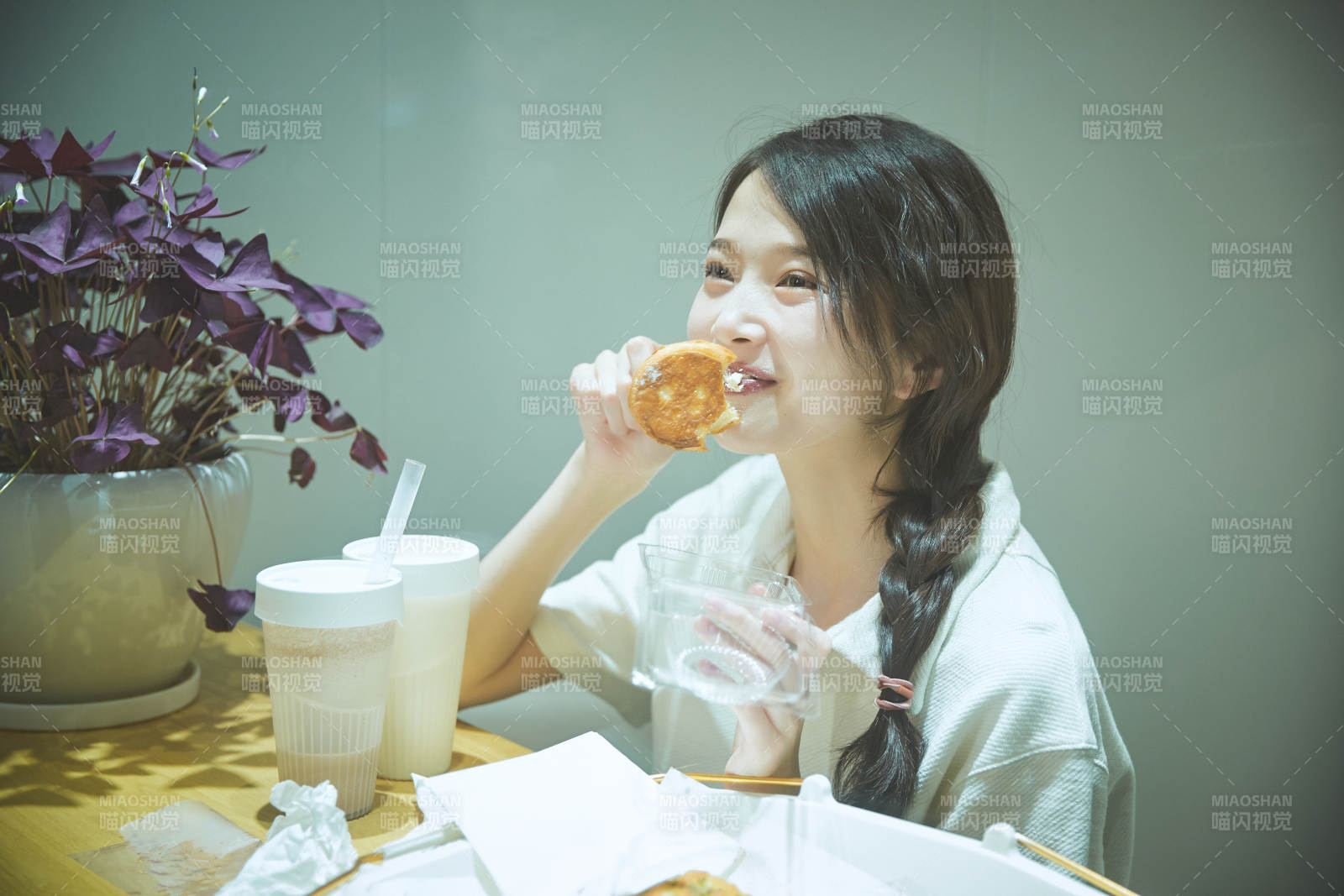 在烘焙店吃面包喝牛奶的可爱亚洲少女图片