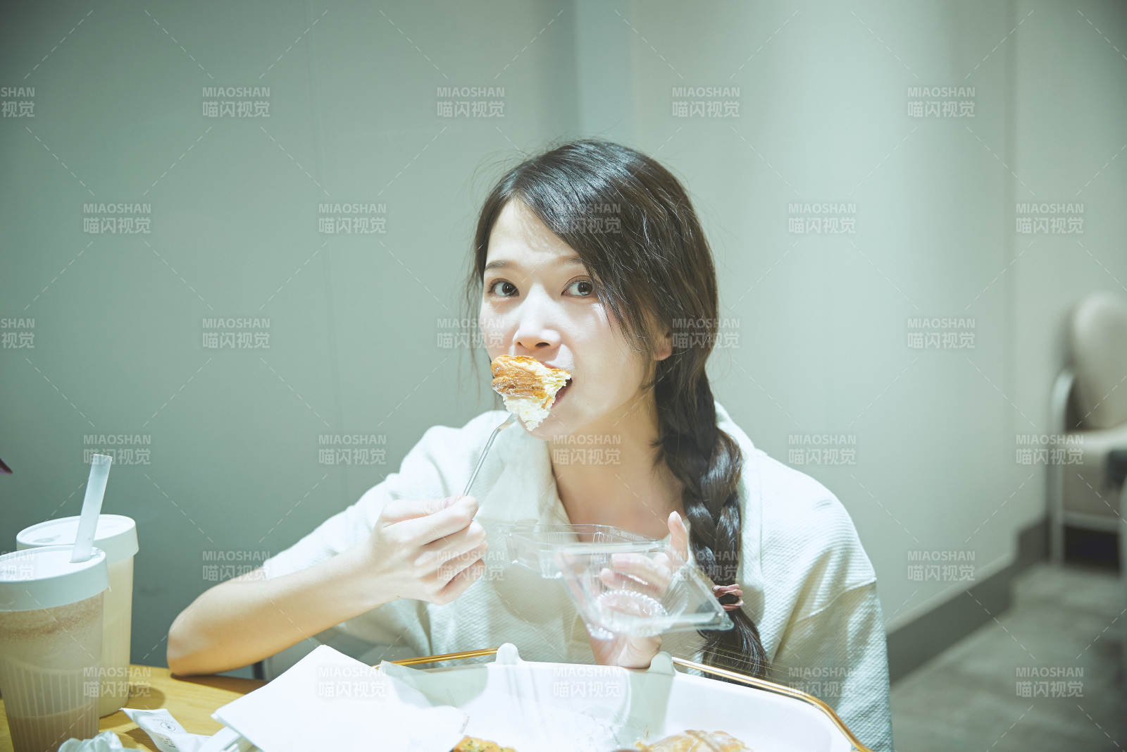 在烘焙店吃面包喝牛奶的可爱亚洲少女图片