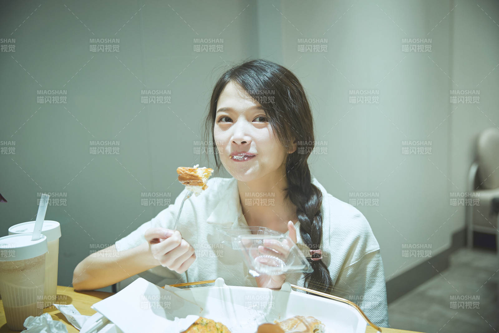 在烘焙店吃面包喝牛奶的可爱亚洲少女图片