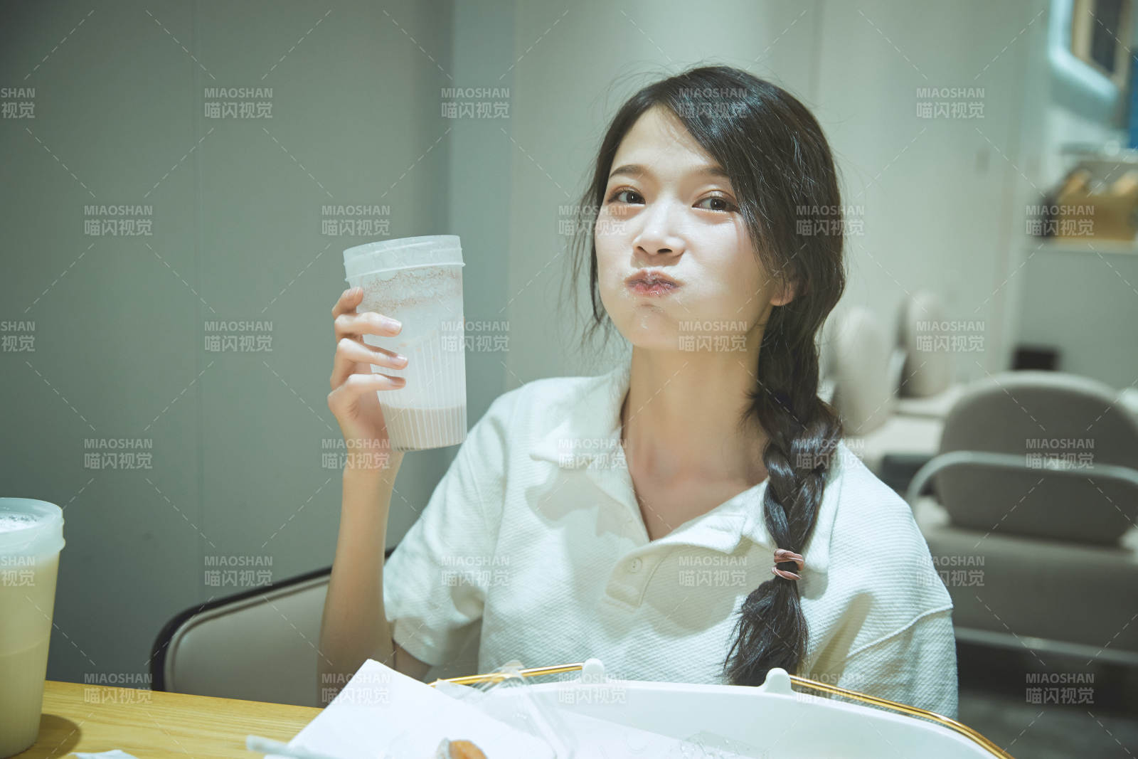 在烘焙店吃面包喝牛奶的可爱亚洲少女图片