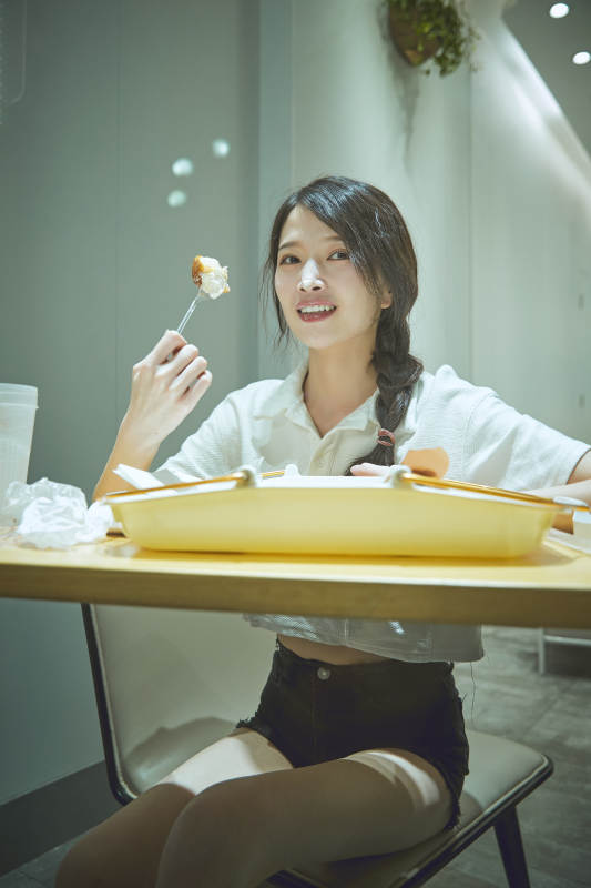 在烘焙店吃面包喝牛奶的可爱亚洲少女图片